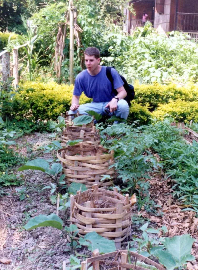 Home gardener using basket composting to enrich soil and grow vegetables sustainably
