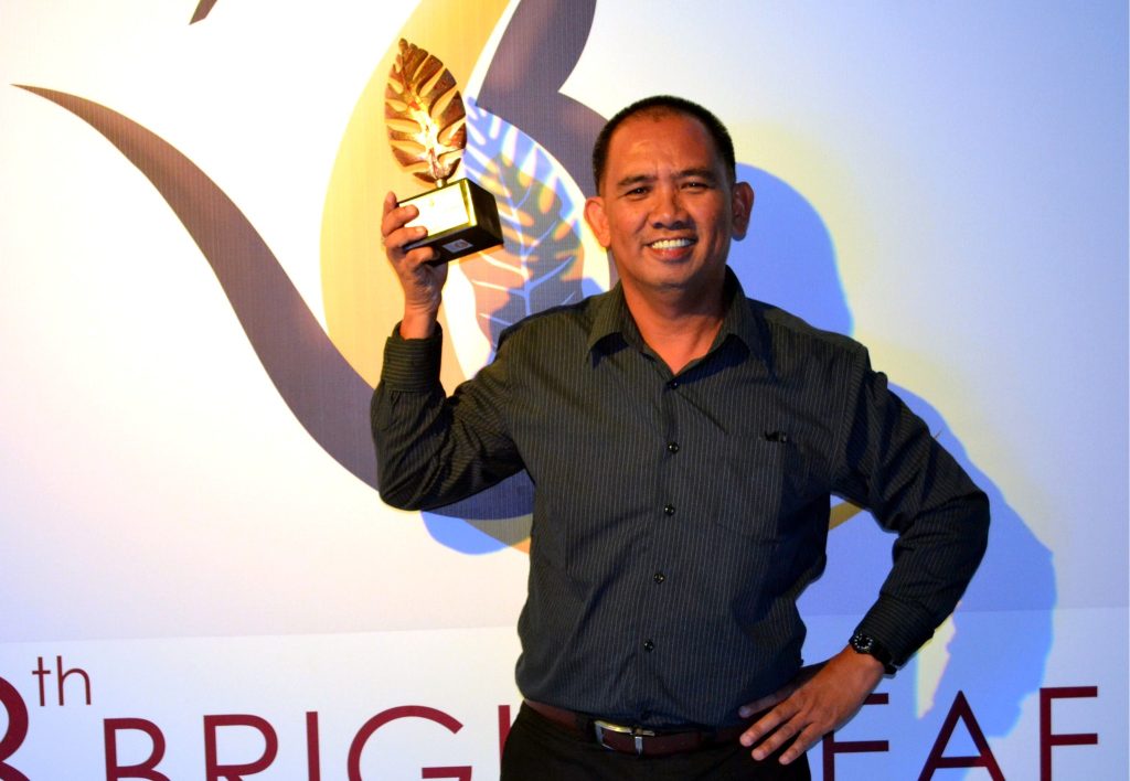 Henrylito D. Tacio holding the Bright Leaf Award for excellence in journalism