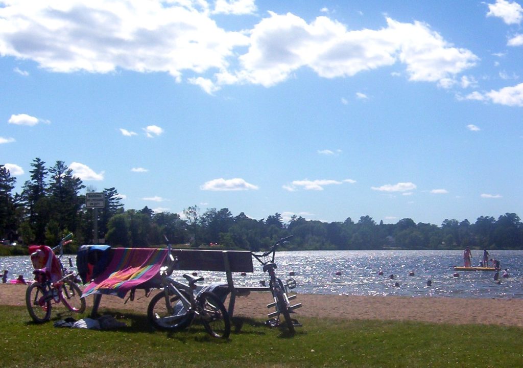 People swimming and relaxing at a lake during summer in Grand Rapids Minnesota travel