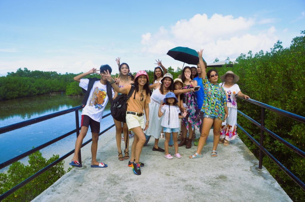 A family walking along a pathway inside the mangrove forest in Mati City, Davao Oriental.