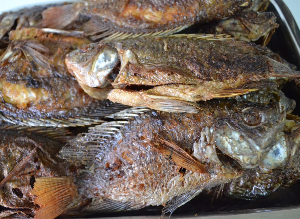 Fried tilapia displayed for sale in a local market, as pine tree pollen tilapia research explores improving tilapia production.