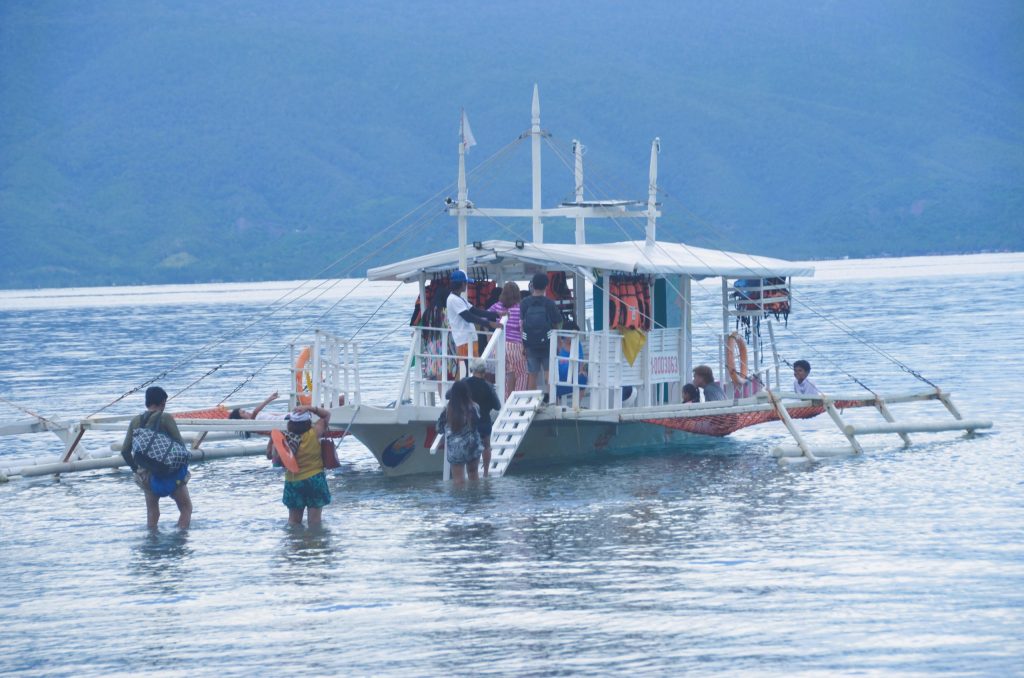 Tourists boarding a boat for an island hopping adventure in Mati City, Davao Oriental.