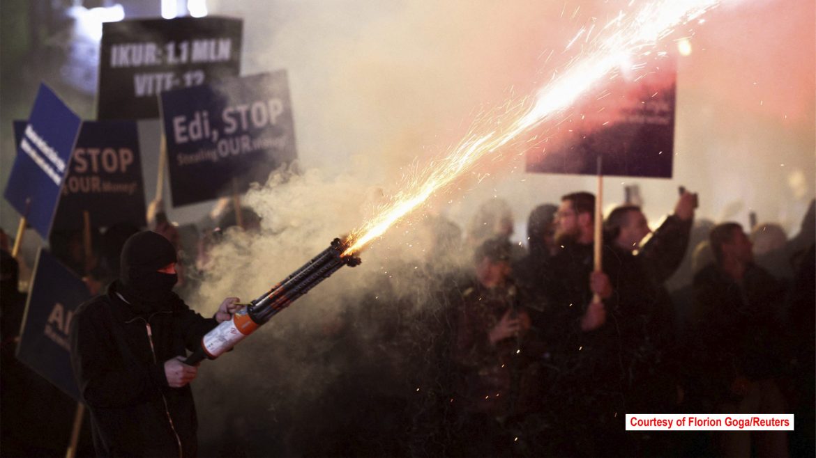 Albanian opposition protesters ignite flares during an anti-government protest near the Prime Minister’s office in Tirana