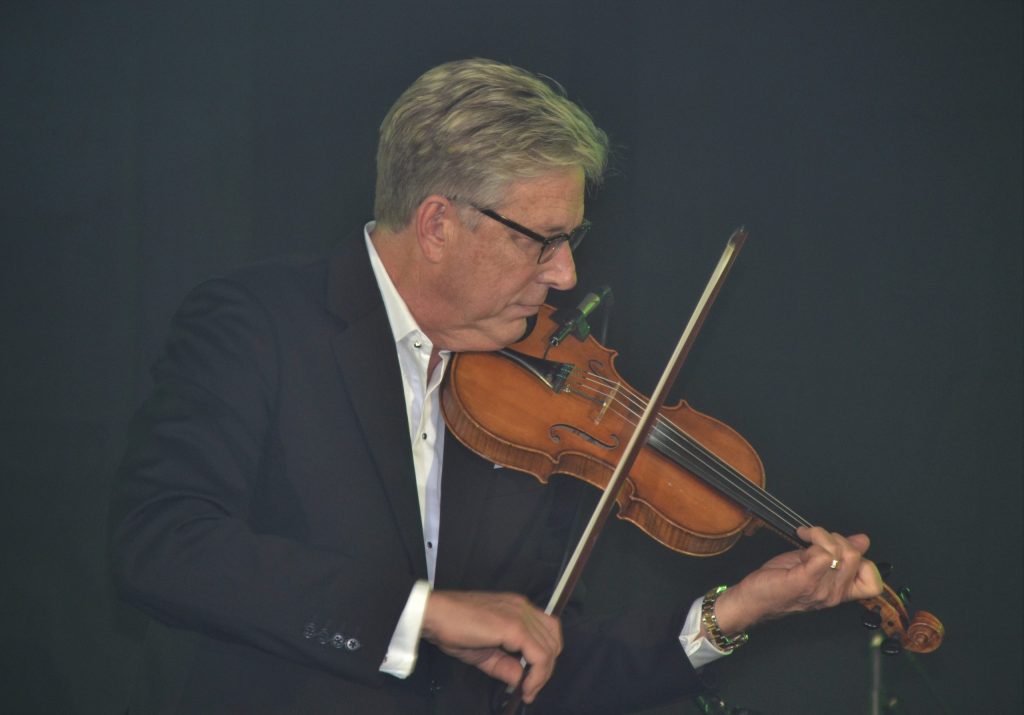 Don Moen music ministry showcased as he plays the violin during a worship performance