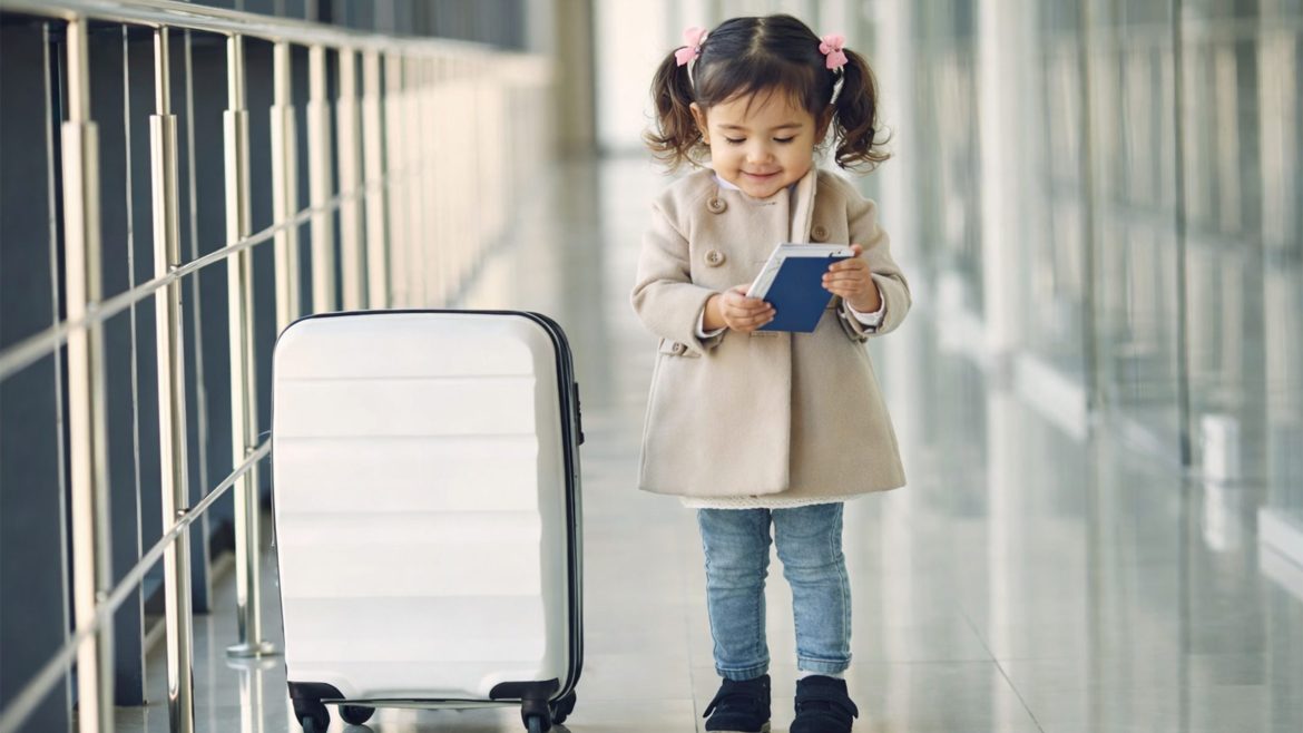 Filipina toddler with suitcase preparing for travel during Holidays February 2026