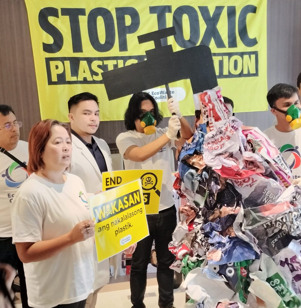Environmental advocates display toxic plastic tarpaulins during a protest against plastic pollution