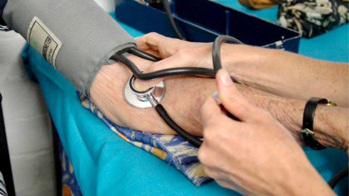 Healthcare professional checking blood pressure using a digital monitor