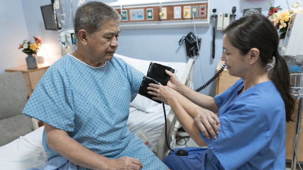Nurse checking blood pressure of a stroke patient to monitor stroke warning signs