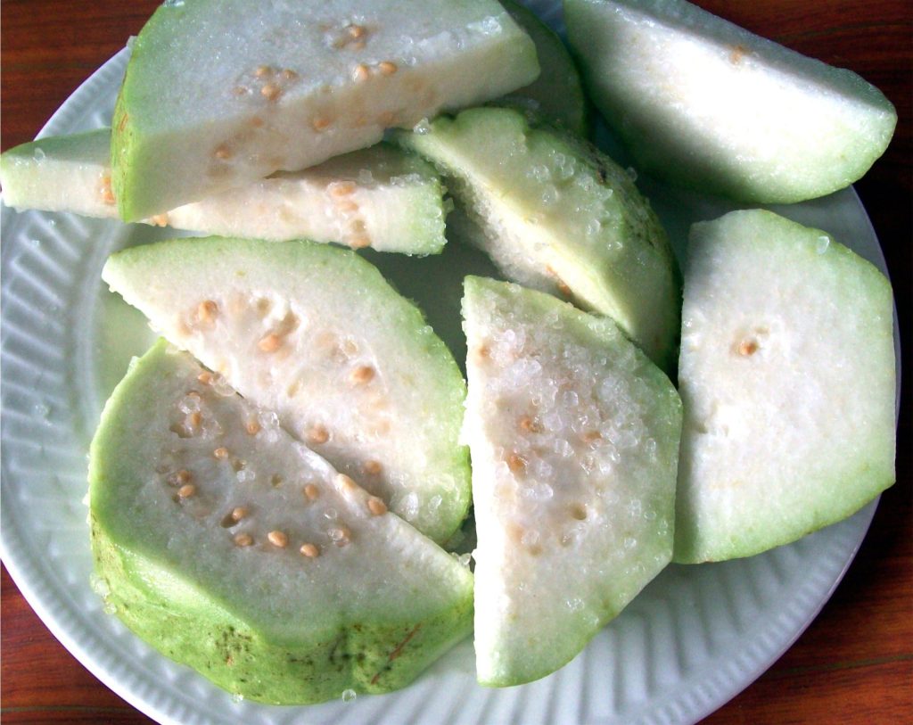 Fresh slices of tropical guava fruit showing the white flesh and seeds rich in vitamin C.