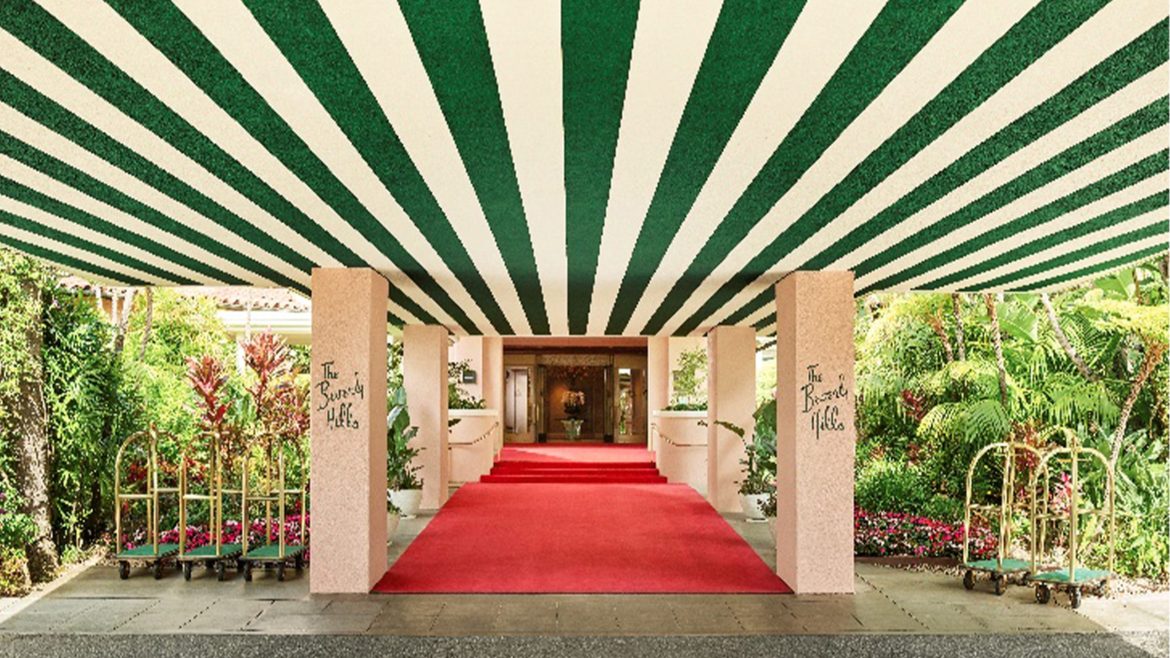 Entrance of The Beverly Hills Hotel with green striped canopy and red carpet walkway