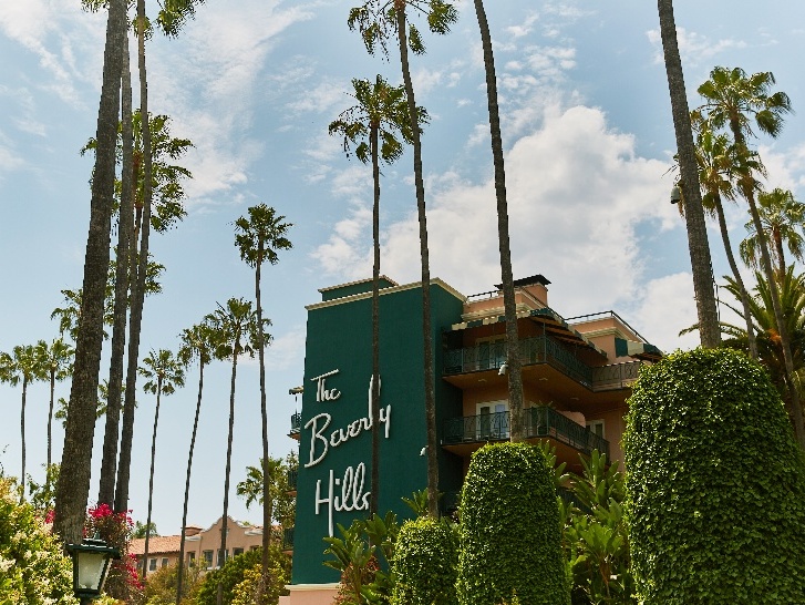 Exterior view of The Beverly Hills Hotel surrounded by palm trees in California