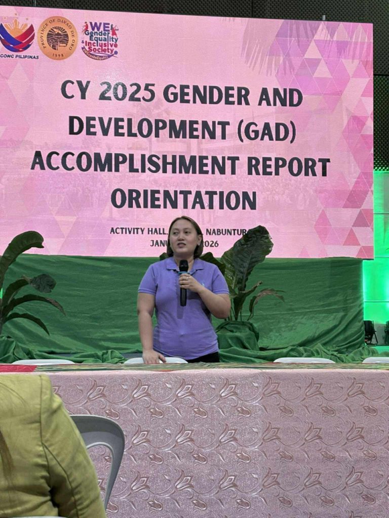 Speaker presenting the Gender and Development (GAD) accomplishment report during the National Women’s Month celebration in Davao de Oro.