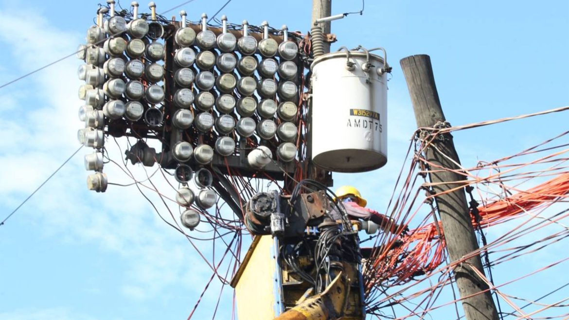 Electric utility worker repairing power lines and meters on a pole as electricity prices rise in the Philippines