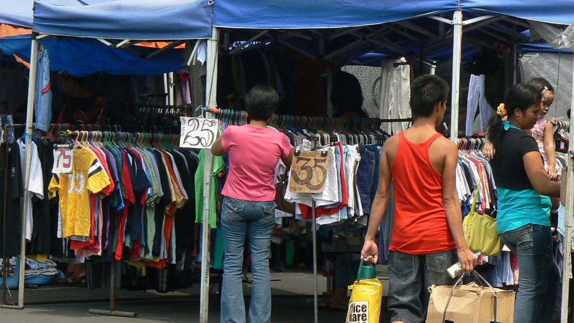 Shoppers walk past stalls at a street market in Manila amid discussions about the Philippines budget deficit and rising government spending