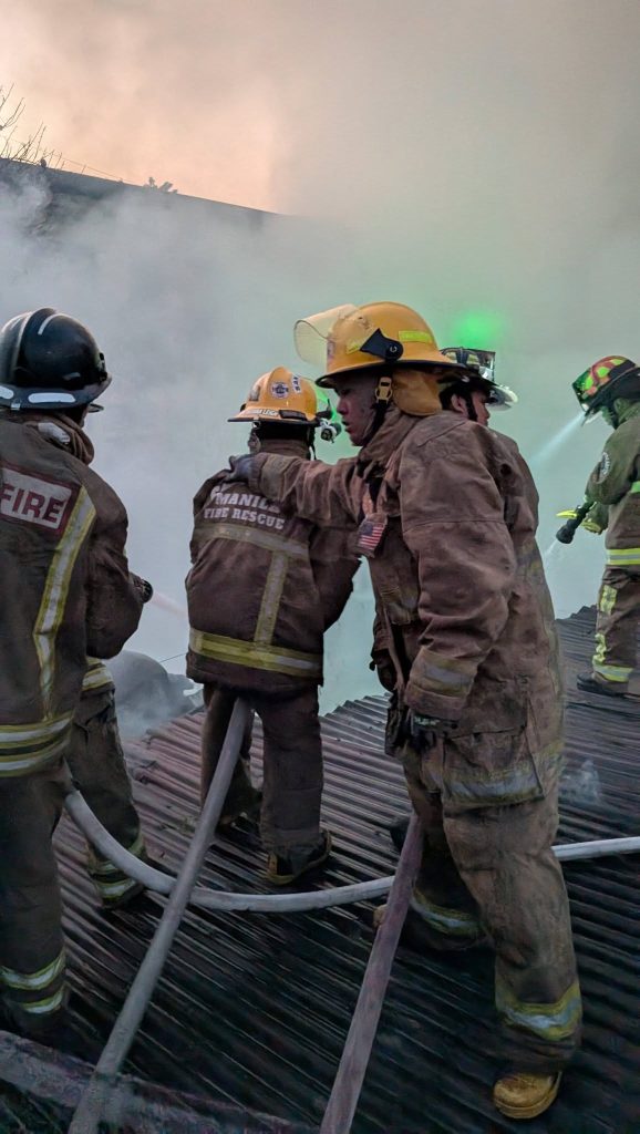 San Andres volunteer firefighters using hoses during a fire suppression operation