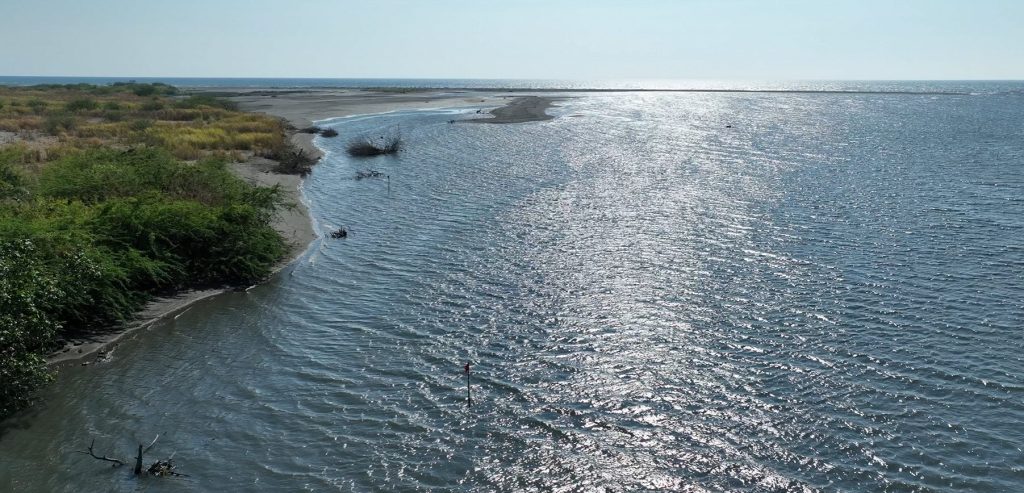 A wide aerial view of the Amnay River mouth surrounded by vegetation in Occidental Mindoro.