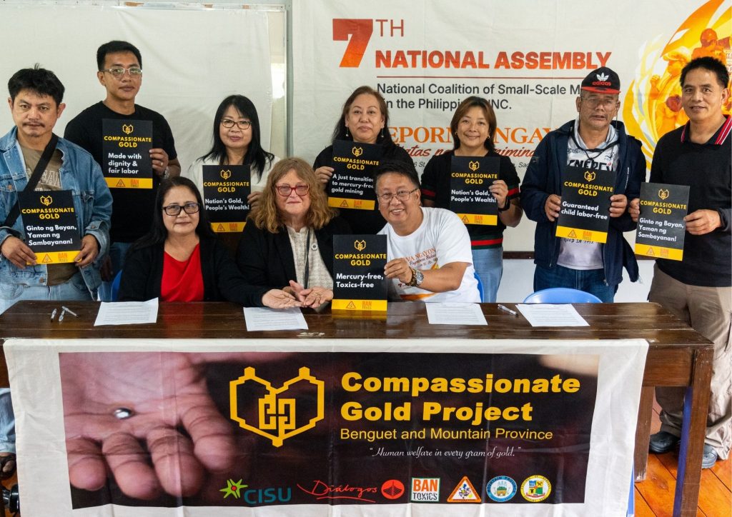 Delegates signing documents at small-scale mining assembly supporting law reform Philippines