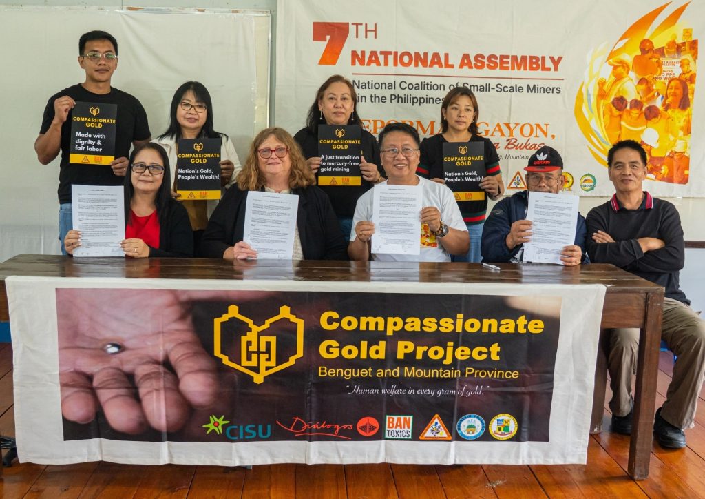 Mining advocates holding advocacy signs during assembly supporting small-scale mining law reform Philippines