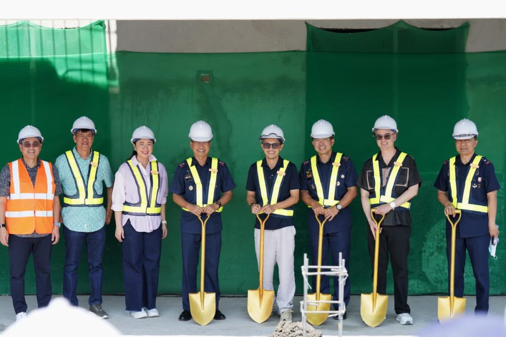 Construction personnel and government officials pose during a site visit at the forensic laboratory facility.